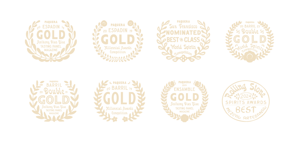 A collection of award badges for Paquera Mezcal, displayed in a horizontal row. The badges include gold and double gold awards from various spirits competitions, including tasting panels and the San Francisco World Spirits Competition. The final badge on the right features the Rolling Stone 2024 Spirits Awards, recognizing Paquera Mezcal as the best in the Mezcal Artesanal category.